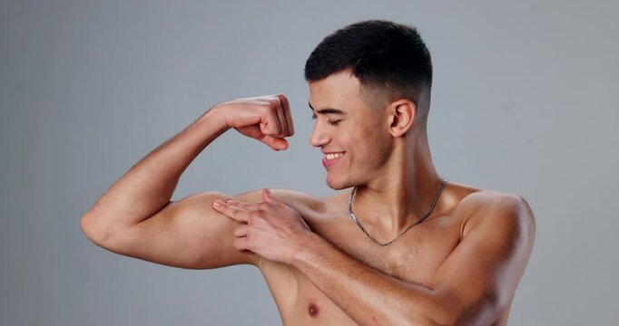 Face, flexing and man with wellness, bicep and workout with bodybuilder on gray studio background. Portrait, person and model showing muscle, training and fitness with confidence, pride and athlete