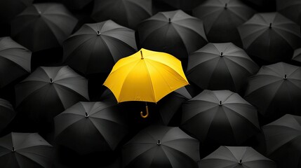 One yellow umbrella standing out in a crowd of black umbrellas, symbolizing the strength of being different