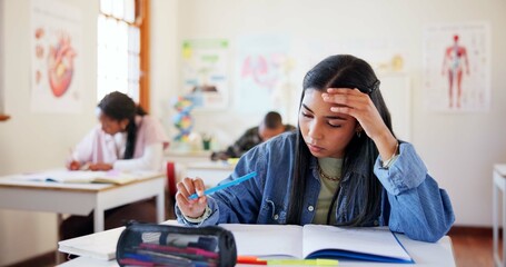 Frustrated girl, student or book with exam for difficult test, stress or question in classroom at school. Young, female person or teenager with notebook, anxiety or nerves for assesment or assignment