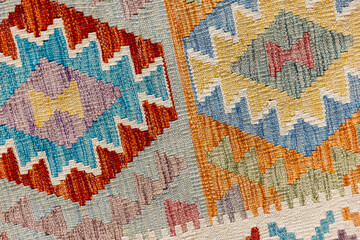 Colorful woolen carpet with geometric ornament. Macro photo