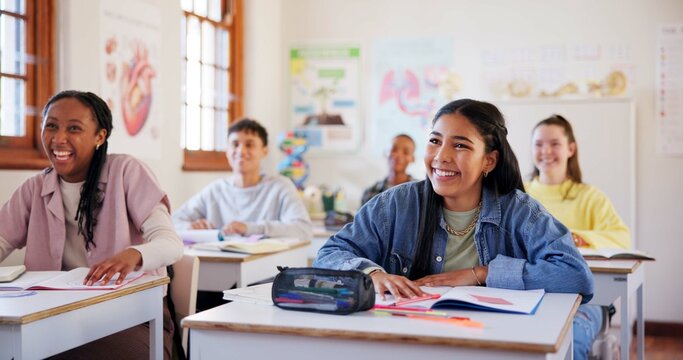 Happy teenagers, students and laughing with humor in classroom for funny joke together at school. Young, group or learners with smile, books or desk for fun education, learning or youth development