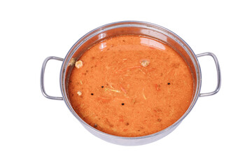  A round metal pot filled with a simmering broth, with visible ingredients and spices.