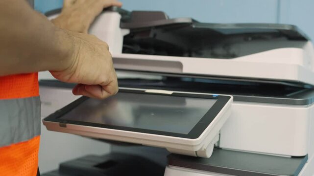Close up, Hand of construction worker press start on touch screen on photocopier machine to copy or scanning document in office. Construction worker copy document at office or workplace