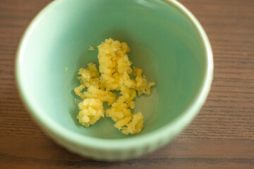  Minced Garlic Clove in a Small Blue Bowl Close-Up