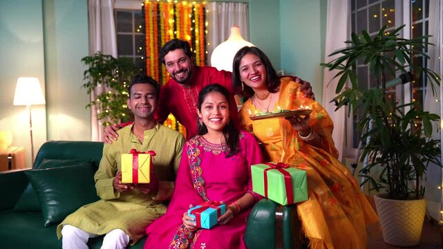 Indian family of four dressed in traditionals celebrates diwali with diyas ,gifts and love in their beautifully decorated home creating cherished memories together