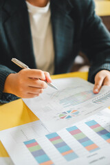 Close-up of a business professional analyzing financial data and charts, highlighting strategic planning and decision-making in an office setting.