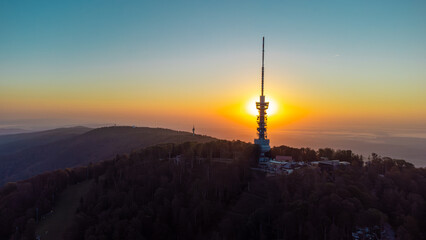Obraz premium Early morning sunrise panorama of Sljeme above Zagreb with visible antenna tower, big massive hill and layers of fog below in valley. Epic panorama above zagreb