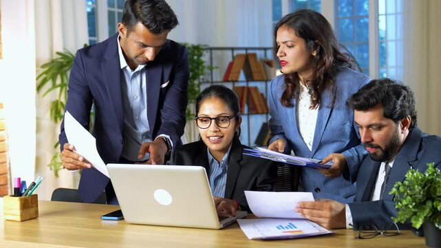 Young Indian business professionals or marketing team is working together in the office, happily sharing creative ideas and plans for a project to make their marketing better and exciting