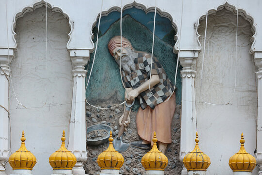 Guru Nanak digging the earth. Bas-relief on the wall of the Sikh temple in Manikaran, Northern India.