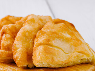 Freshly baked langos, savoury deep fried flat bread on wooden plate