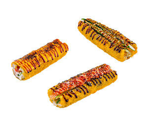 Three delicious sushi rolls are covered in panko breadcrumbs and drizzled with sauce
