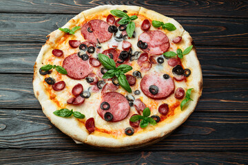 Pizza with mozzarella cheese , salami sausages , olives , and basil