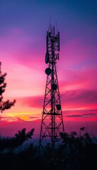 Dramatic sunset silhouette of telecommunication tower and satellite dish against colorful sky