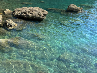 Sea beautiful clear turquoise emerald water with stones.