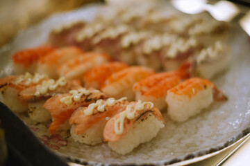 selective focus. Japanese sushi food. Sushi set plate served with ginger and soy sauce. Sushi rolls, salmon nigiri, shrimp nigiri, tuna nigiri
