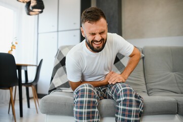 Man suffering from stomach ache at home. Food poisoning