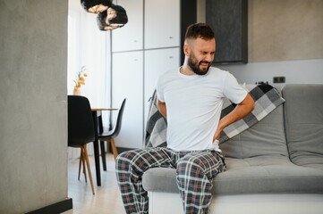 Back pain, kidney inflammation, man suffering from backache at home, health problems concept