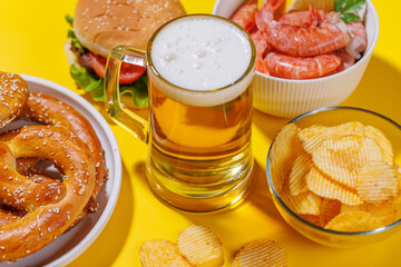 A vibrant photo showcasing a glass of beer surrounded by various snacks and fast food
