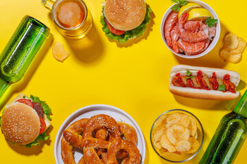 A vibrant photo showcasing a glass of beer surrounded by various snacks and fast food