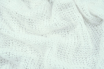 Soft white knit fabric draped gracefully on a light background during daylight hours