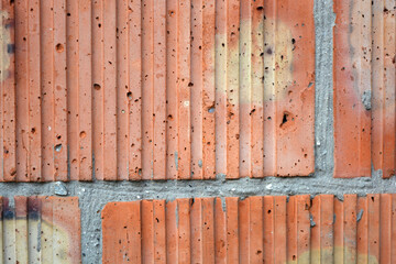 Building materials, brickwork made of red-yellow bricks and gray cement. Construction background.