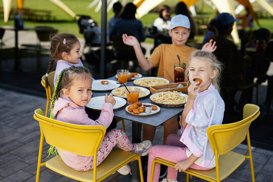 Group of children enjoying snacks at an outdoor cafe