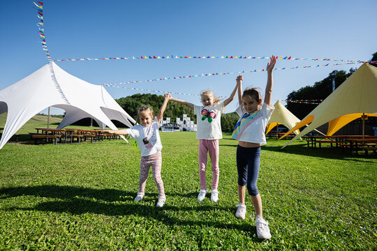 Joyful kids playing at an outdoor festival under sunny skies