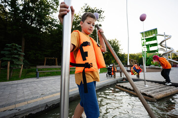 Boy enjoying outdoor adventure park with water raft