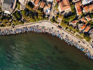 Aerial view of a coastal town Pomorie, Bulgaria, showcasing vibrant architecture along the shoreline against a backdrop of blue waters and sky