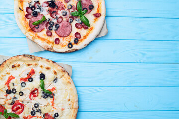 2 pizza with mozzarella cheese , salami sausages , olives , chicken , pineapple and tomatoes