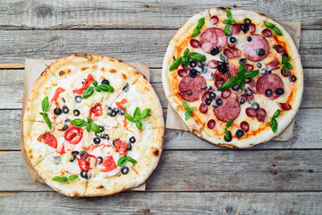 2 pizza with mozzarella cheese , salami sausages , olives , chicken , pineapple and tomatoes