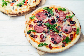 2 pizza with mozzarella cheese , salami sausages , olives , chicken , pineapple and tomatoes