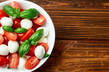Basil leaves , cherry tomatoes and mozzarella cheese . In bowl food photography
