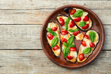 Italian mini pizza . Aubergine (eggplant ) with mozzarella cheese and basil . On rustic background