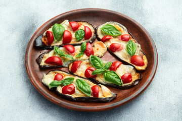 Italian mini pizza . Aubergine (eggplant ) with mozzarella cheese and basil . On rustic background