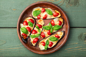 Italian mini pizza . Aubergine (eggplant ) with mozzarella cheese and basil . On rustic background