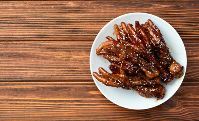 Caramelized korean or Chinese chicken foots ( paws ) with sesame . Top view