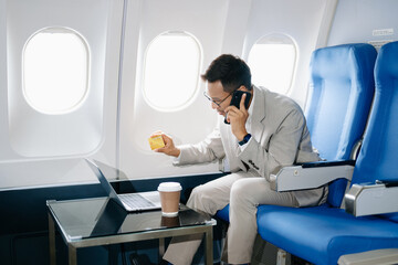 Fototapeta premium Asian man sitting in a seat in airplane and looking out the window going on a trip vacation travel concept.