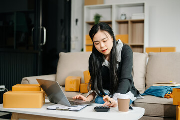 Young businesswoman managing online sales and shipping from a modern home office.