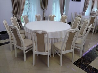 Table with white tablecloth chairs exquisite interior round shape horizontal