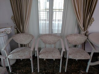 Three elegant chairs light color on background window empty horizontal