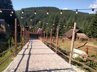 Stone road under garlands of lamps overlooking mountain forest horizontal