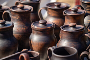 A collection of brown ceramic mugs and pitchers