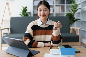 woman holds the key to her new house, securing a loan to manage the financial aspects of her home ownership, balancing finance and the responsibilities of a housing loan
