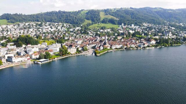 Aerial panoramic view of the city of Zug from above Lake Zug in Switzerland featuring the Zugerberg mountain in the background