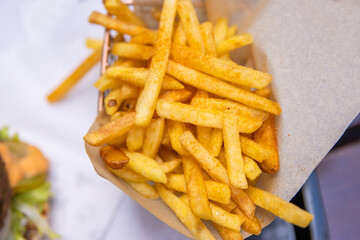 Closeup of a serving of of crispy golden French fries on a restaurant table. A perfect snack or...