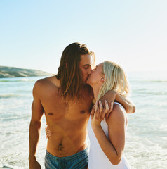 Fototapeta premium Smile, couple and kiss with love on beach for romance date, sea water and support of tropical vacation. Happy, woman and man holding hands with loyalty, embrace and holiday journey for summer morning