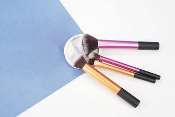 makeup brushes with coaster on blue and white background