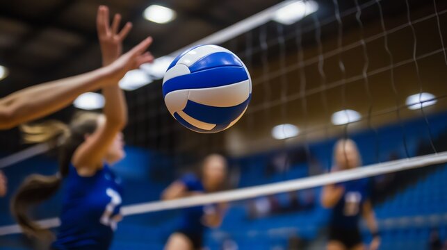 A volleyball is in mid-air as players on the court reach for it.