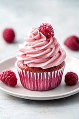 Cupcake with pink frosting and raspberries
